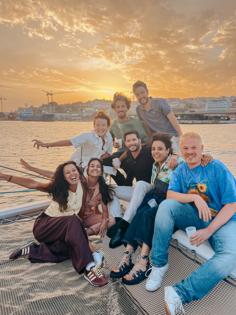 Team photo at sunset by the Tejo River in Lisbon.